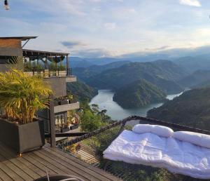 een bed op een balkon met uitzicht op een rivier bij AVANI Boutique Hotel in Norcasia
