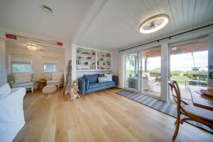 ein Wohnzimmer mit einem blauen Sofa und einem Tisch in der Unterkunft Lakefront NY Getaway with Boat Dock and Kayak! 