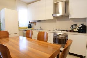 a kitchen with a wooden table and wooden chairs at Appartamento da Paola in Pescara