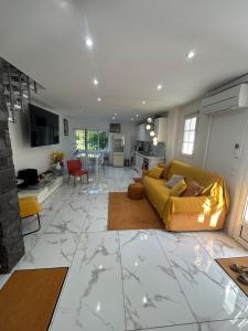 a living room with a yellow couch and a kitchen at Les chambre de amour in Urrugne