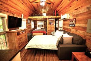 um quarto num trailer com uma cama e uma televisão em The Americana - Parker Creek Bend Cabins em Murfreesboro