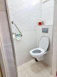 een badkamer met een wit toilet in een stal bij Luxe woning in Paramaribo Zuid / Casa Birambie in Paramaribo