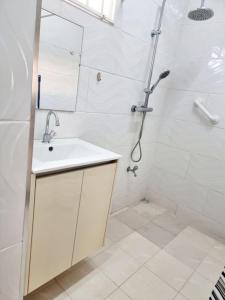 baño blanco con ducha y lavamanos en Luxe woning in Paramaribo Zuid / Casa Birambie, en Paramaribo