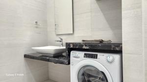 y baño con lavadora y lavamanos. en De lenco Residence 4, en Atenas