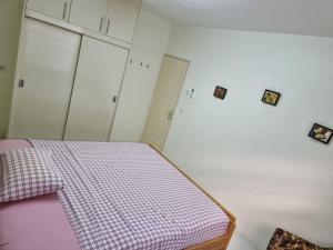 een slaapkamer met een bed met een geruite deken bij Luxe woning in Paramaribo Zuid / Casa Birambie in Paramaribo