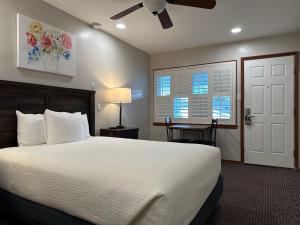a bedroom with a large bed and a ceiling fan at Bluebird Inn in Cambria