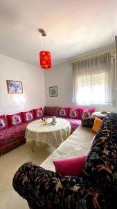 sala de estar con sofá rojo y mesa en Appartement meublé au centre ville, en Tetuán