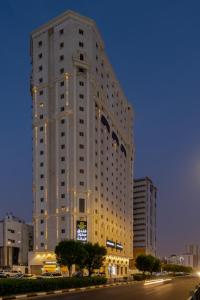 duży biały budynek jest oświetlony w nocy w obiekcie Snood Al Dana Hotel w Mekce