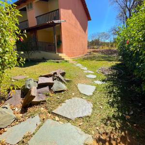 una pasarela frente a una casa con rocas en Hotel Fazenda Tia Dora en Três Marias