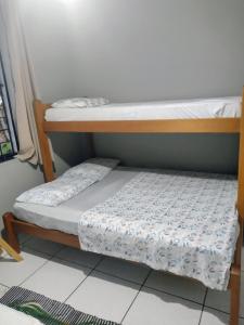 dwa łóżka piętrowe siedzące obok siebie w pokoju w obiekcie Pousada Cantinho D´Lilica w mieście Balneário Praia do Leste