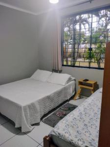 a bedroom with two beds and a window at Pousada Cantinho D´Lilica in Balneário Praia do Leste