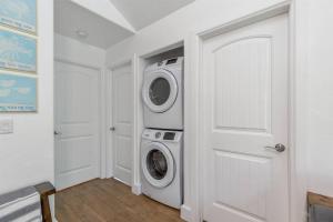 a white laundry room with a washer and dryer at Cozy Cottage • 2 King Beds • Grove • Kayaks • Washer/Dryer in Grove