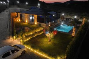 une voiture garée devant une maison avec piscine dans l'établissement Black Swan Villas Kadıllı, à Gebze