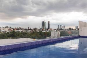 een zwembad met een skyline van de stad op de achtergrond bij Departamento en Condesa con Alberca y Gimnasio in Mexico-Stad