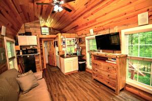 - soggiorno e cucina in una baita di tronchi di The Americana - Parker Creek Bend Cabins a Murfreesboro