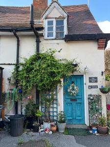 a house with a blue door and some plants at The Armadas Rest in Coleshill