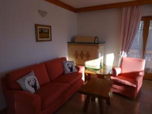 a living room with a red couch and a table at CASA VIDI in Madonna di Campiglio