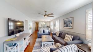 a living room with a couch and a tv at True Blue Villas Your 3BR Oasis in Pawleys Island