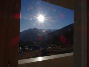 a window with a view of the sun and mountains at CASA VIDI in Madonna di Campiglio