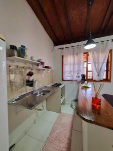 uma cozinha com um lavatório e uma bancada em Recanto dos Mares - Chalés e suíte - Bertioga-SP-Próximo Sesc em Bertioga