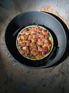 a pizza is cooking in a pan on a stove at Bedouin Family Camp in Wadi Rum