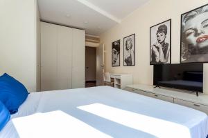 una camera con un grande letto e una TV a schermo piatto di Bellezza14 - Appartamento Porta Romana / Bocconi a Milano