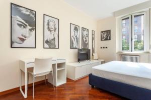 a bedroom with a bed and a desk and pictures on the wall at Bellezza14 - Appartamento Porta Romana / Bocconi in Milan