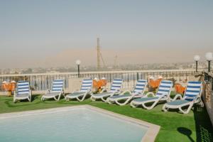 a group of blue and white chairs sitting next to a pool at Queens Valley Hotel in Luxor