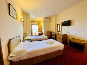 Un pat sau paturi într-o cameră la Queens Valley Hotel