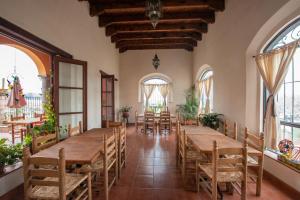 une salle à manger avec des tables et des chaises en bois dans l'établissement Hotel Camino Antiguo, à Guanajuato