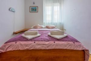a bedroom with a large bed with a purple comforter at Room Laura in Crikvenica