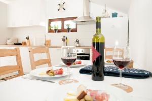 a table with two wine glasses and a bottle of wine at Apartment Ivan in Drvenik Mali