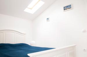 a white bedroom with a bed with blue sheets at Apartment Ivan in Drvenik Mali +17 photos