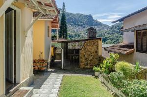una puerta a una casa con una montaña en el fondo en Chamosa e aconchegante casa em Petrópolis VGL041 en Petrópolis