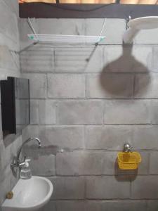 ein Badezimmer mit einem Waschbecken und einer weißen Ziegelwand in der Unterkunft Chalé com privacidade em Imbassai in Mata de Sao Joao