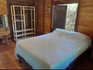 ein Schlafzimmer mit einem großen weißen Bett in einem Zimmer in der Unterkunft Chalé com privacidade em Imbassai in Mata de Sao Joao