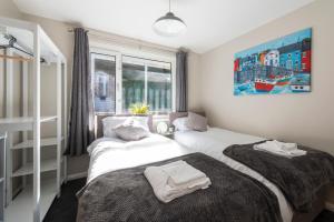 1 dormitorio con 2 camas y ventana en 5 Bedroom Detached Beach House Poole, en Parkstone