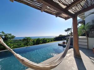 a hammock on the side of a house with a swimming pool at Casa Jacito in Ayampe