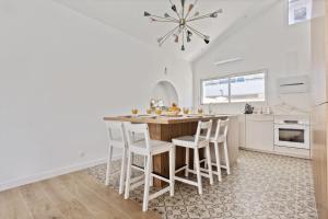 a kitchen with a wooden table and white cabinets at Maison Roccia - Welkeys in Anglet