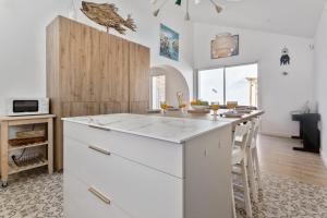 a kitchen with a white island in a room at Maison Roccia - Welkeys in Anglet +9 photos