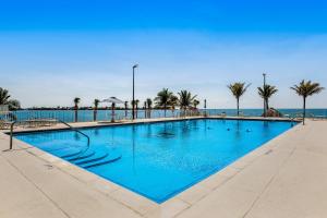 una gran piscina azul con palmeras y el océano en Green Pineapple, en Marathon