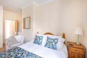 een slaapkamer met een bed met blauwe en witte kussens bij Room with Private Bath in Pontcanna in Cardiff