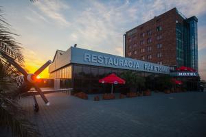 a building with a sign for a hotel with a sunset at Terminal Hotel in Wrocław