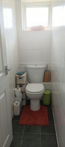 a small bathroom with a toilet and a window at Rockrose Stay in Cardiff
