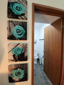 une salle de bains avec trois photos de roses sur le mur dans l'établissement Bonito Departamento en Americana, à Guadalajara