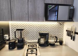 a kitchen counter with two coffee makers and a microwave at Bonito Departamento en Americana in Guadalajara