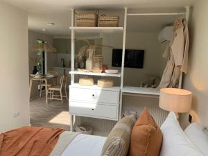 um quarto com um armário com uma cama e uma mesa em West Wittering Beach Getaway em West Wittering
