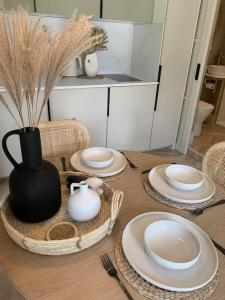 uma mesa com placas brancas e um vaso sobre ela em West Wittering Beach Getaway em West Wittering