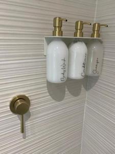 a bathroom wall with two whiteodorizers on a shelf at West Wittering Beach Getaway in West Wittering +11 photos
