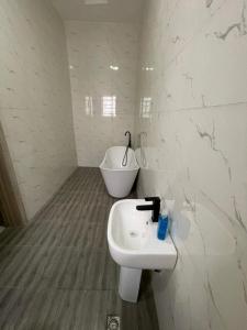 uma casa de banho branca com um lavatório e um WC em FayFays Edifice C1 A Luxury 4 Bedroom Terrace Duplex em Lekki